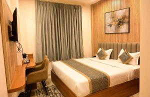 a bedroom with a bed and a desk and a television at Hotel Banaras Vandanam in Varanasi +18 photos