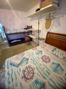 a bedroom with a bed and a desk in it at Hospedagem Mandala in Ubatuba