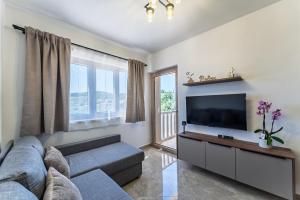 a living room with a couch and a flat screen tv at Milina Residence - Lumbarda in Lumbarda