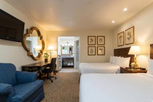 a hotel room with two beds and a desk and a couch at Sacramento Inn & Suites Cal Expo I-80 in Sacramento