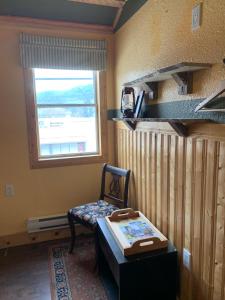 ein Zimmer mit einem Stuhl, einem Tisch und einem Fenster in der Unterkunft Hotel Midway in Midway