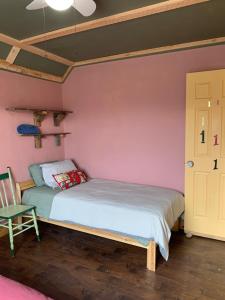 ein kleines Schlafzimmer mit einem Bett und einem Stuhl in der Unterkunft Hotel Midway in Midway