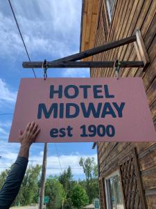 Eine Person hält ein Schild mit der Aufschrift „Hotel Midway“ hoch. in der Unterkunft Hotel Midway in Midway