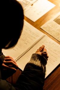 a person sitting at a table with their hand on a manuscript at Local Knot Backpackers in Nagano +16 photos