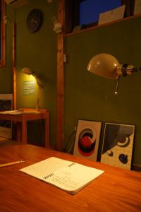 a desk with a lamp and a paper on it at Local Knot Backpackers in Nagano
