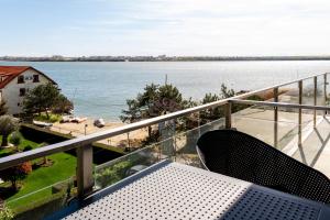 a balcony with a bench and a view of the water at Vila Victor Mizuumi in Mamaia
