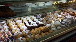 una vitrina llena de muchos pasteles diferentes en Sant'Agostino Affittacamere, en Reggio Calabria