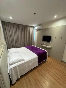 a hotel room with a bed and a tv at LUXO Premium Studio Pelinca in Campos dos Goytacazes +17 photos