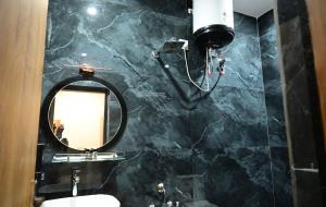 a black marble bathroom with a mirror and a sink at Hotel Banaras Vandanam in Varanasi