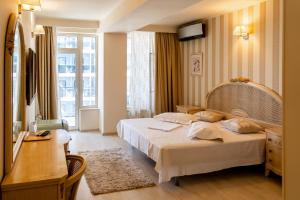 a hotel room with a bed and a desk at Vila Victor Mizuumi in Mamaia