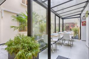 a conservatory with a table and chairs and plants at Marmotel Etoile in Paris