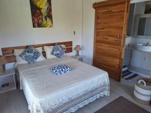 a bedroom with a bed with blue pillows on it at Poisson d'Or Guest House in Port Mathurin
