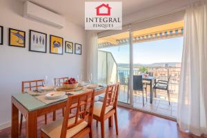 a dining room with a table and chairs and a balcony at Infinite View Palamós in Palamós