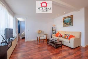 a living room with a couch and a tv at Infinite View Palamós in Palamós