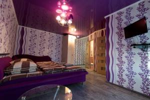 a purple room with a bed and a table at Central Supermarket Apartment 2019 in Kherson