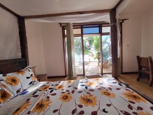 a bedroom with a bed with a floral bedspread at Bwereusunsetbungalow in Kidoti
