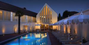 a hotel with a swimming pool with chairs and umbrellas at Hôtel Maison Borrèze in Souillac