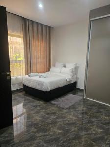 a bedroom with a bed and a window at Luxe Apartments in Lusaka