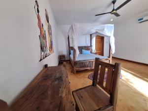a bedroom with a bed and a wooden bench at Bwereusunsetbungalow in Kidoti