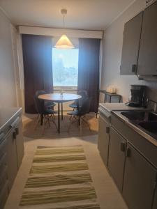 a kitchen with a table and chairs and a table at Apartments at Koulukatu in Savonlinna