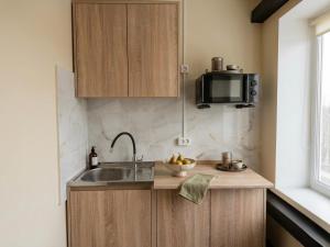 a kitchen with a sink and a microwave at Shpola Central Hotel in Shpola