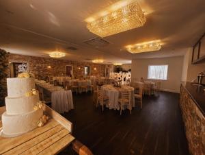 a banquet room with tables and a wedding cake at Grains Bar Hotel in Oldham
