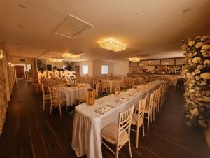 a banquet room with tables and chairs and flowers at Grains Bar Hotel in Oldham