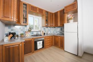 a kitchen with wooden cabinets and a white refrigerator at Villetta Caterina in Procida