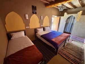 a bedroom with two beds in a room at Riad dar merzouga in Merzouga +13 photos