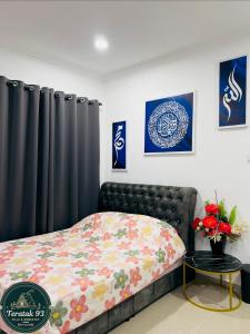 a bedroom with a bed with a floral comforter at Teratak 93 in Karak