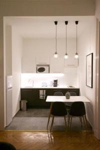 cocina con mesa blanca y 2 sillas en Five Season's Apartment, en Budapest