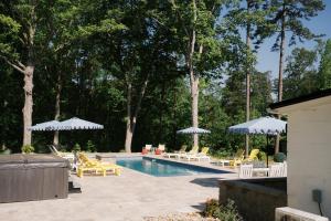 a swimming pool with chairs and umbrellas at Pine Creek Farm in Burkeville