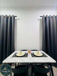 a table with two chairs and a white table with black curtains at Teratak 93 in Karak +16 photos