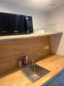 a kitchen counter with a sink and a microwave at Secret garden 3 in Mellehoek +17 photos