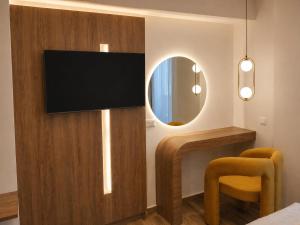 a room with a television on a wall with a mirror at Morfeas City Hotel in Rhodes Town