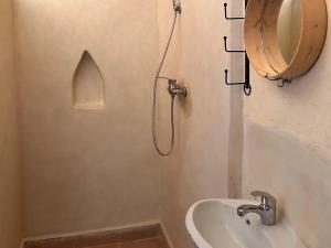 a bathroom with a sink and a mirror at Riad dar merzouga in Merzouga