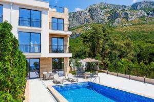 a house with a swimming pool and a mountain at Poljana Olive Homes Pool Residences in Rijeka Reževići