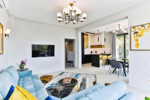 a living room with a blue couch and a table at Poljana Olive Homes Pool Residences in Rijeka Reževići