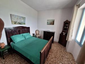 a bedroom with a bed with a green comforter at La Cuccia del Sole Panoramische appartementen met zwembad in Cortemilia +75 photos