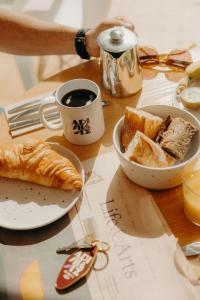 a table with a plate of bread and a cup of coffee at Adishatz Motel in Biscarrosse