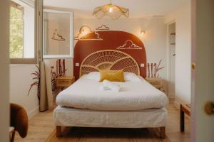 a bedroom with a bed with a large headboard at Adishatz Motel in Biscarrosse