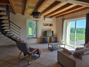 a living room with a staircase and a couch at Maison de campagne in Eymet