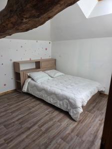 a bedroom with a bed and a wooden floor at Maison de campagne in Eymet