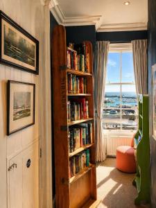 a room with a book shelf filled with books at The Royal Harbour Hotel in Ramsgate