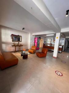 a large living room with orange chairs and a table at Hotel Gran Imperio la 69 in Medellín