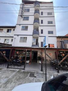a tall white building with cars parked in front of it at Hotel Gran Imperio la 69 in Medellín