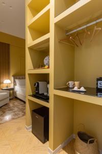 a room with yellow walls and a kitchen with shelves at Palazzo Sospiri in Bisceglie