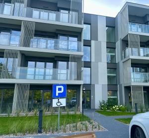 a parking sign in front of a tall building at Port Ostróda 3 - z widokiem na jezioro in Ostróda