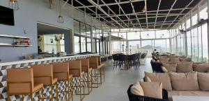 a restaurant with a row of chairs and a bar at Sierra Palms Resort in Freetown