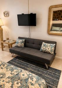 a living room with a couch and a flat screen tv at Studio Bella in Philipsburg